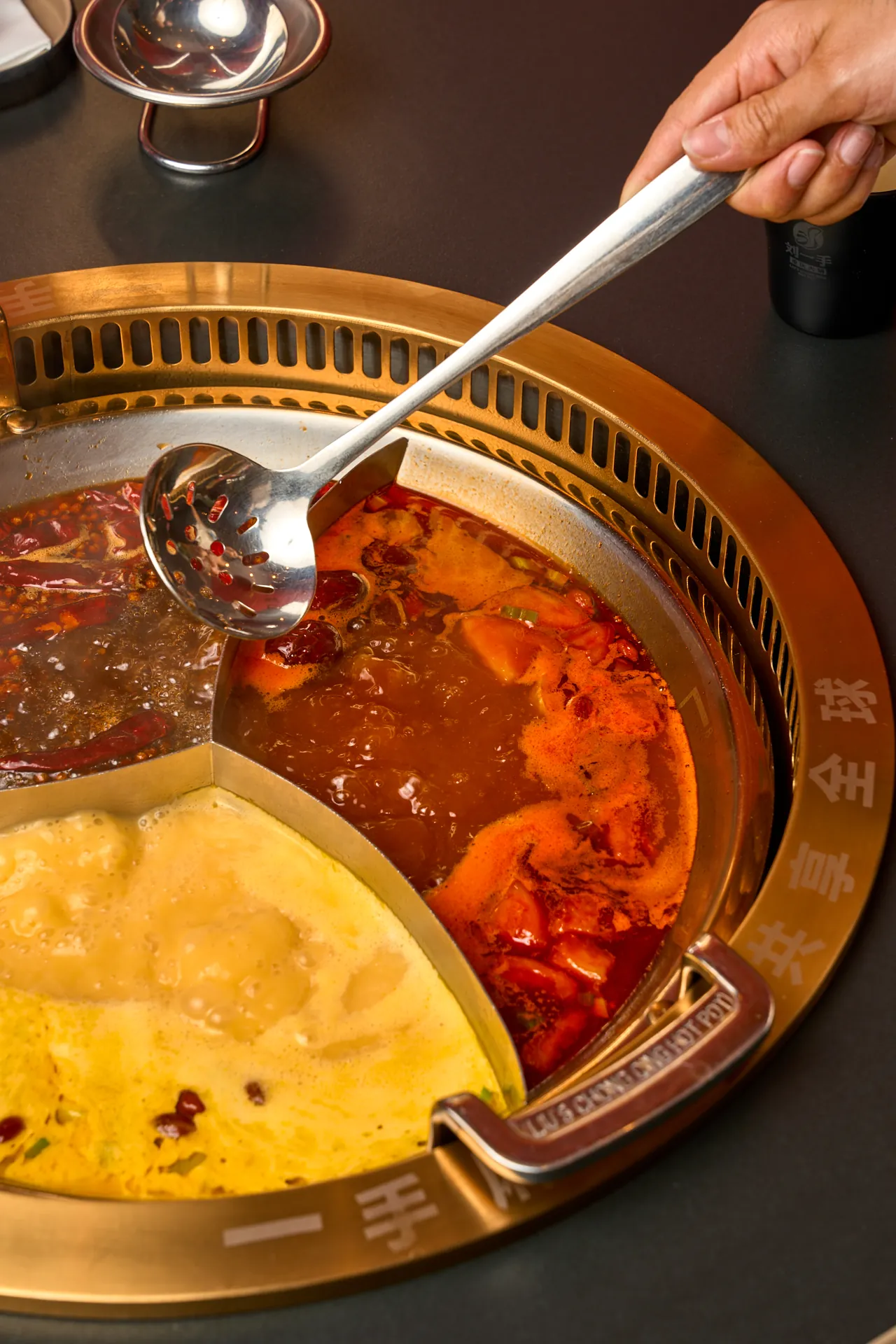 Cucharón en una olla de tres caldos de Liu’s Hotpot Palma