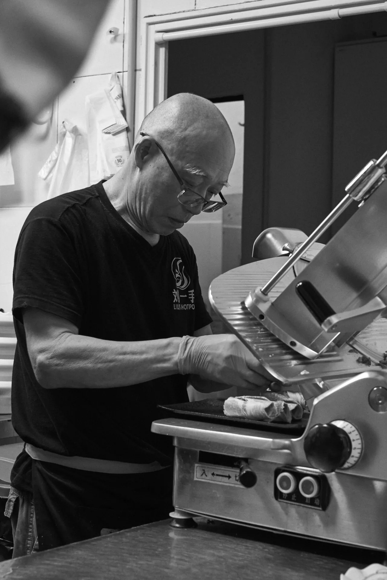 Cocinero con la laminadora de carne, en blanco y negro
